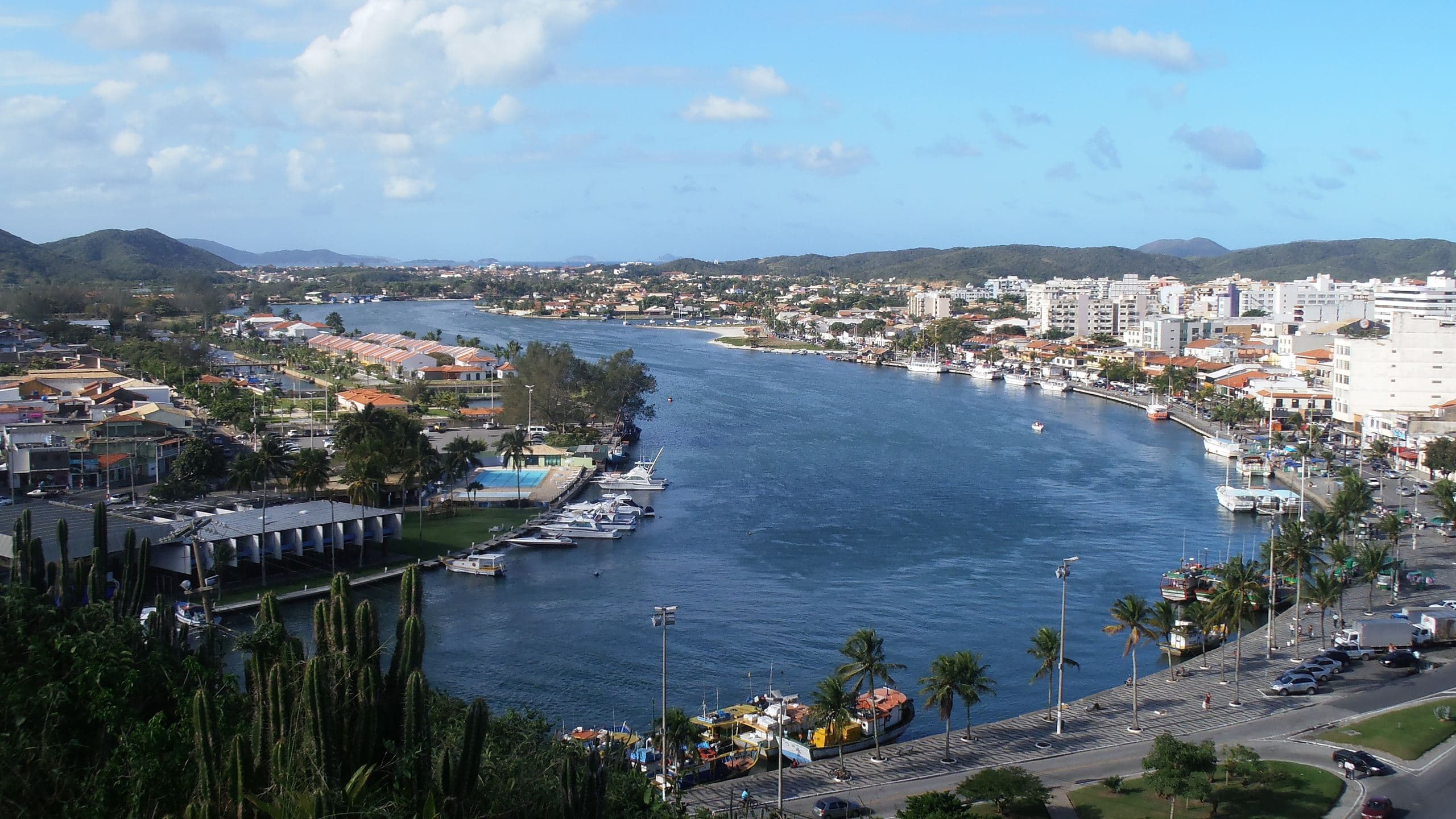 Canal do Itajuru visto do Morro da Guia, com barcos, a orla arborizada e os prédios do Centro de Cabo Frio